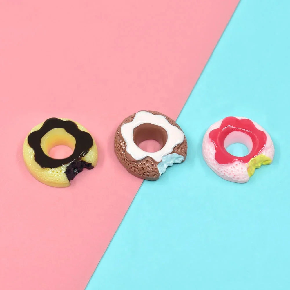 3 different colorful Miniature Dollhouse Doughnuts on a blue and pink floor.