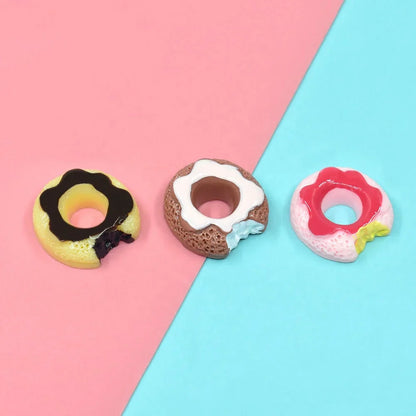 3 different colorful Miniature Dollhouse Doughnuts on a blue and pink floor.